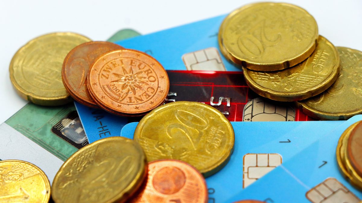 Coins and chip-and-PIN bank cards on a desk — the everyday payments and multi-currency flows a Hong Kong company handles