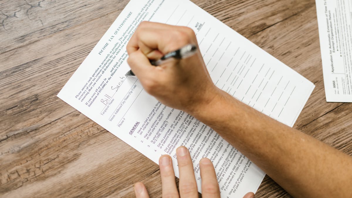 A person completing a tax and business questionnaire by hand at a desk — the administrative groundwork that helps decide whether a Hong Kong company is the right structure